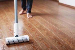 Turbo brush cordless vacuum cleaner close-up cleans the parquet in the house. photo