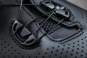 Part of Shoes made of black perforated leather close-up. photo