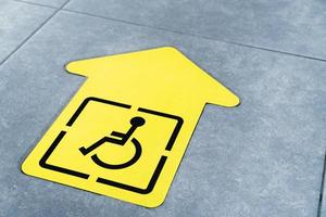 flecha amarilla para discapacitados en el suelo de la sala de espera foto