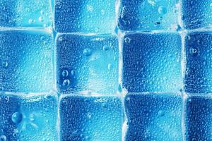 Background of ice cubes with drops in blue color in full screen photo