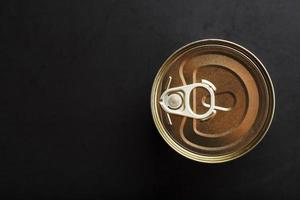 The lid of a metal tin can on a black background photo