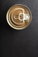 The lid of a metal tin can on a black background photo