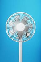 Electric fan in white with a modern design for cooling the room on a blue background photo