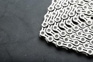 Silver chain of a road bike on a dark textured background photo