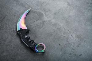 A dagger with a steel blade with a gradient color on a black background. photo