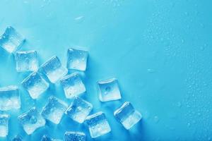 hielo hecho de cubos alineados con gotas sobre un fondo azul con espacio libre foto