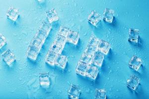 The word ICE is a pattern of ice cubes on a blue background photo