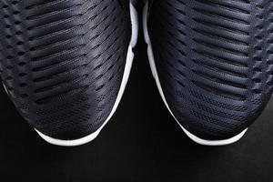 zapatillas deportivas ultramodernas en blanco y negro sobre fondo negro. foto