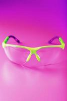 Protective open glasses isolated on a pink background. photo