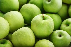 Juicy Green apple close-up with dew drops. photo