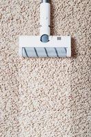 The turbo brush of a cordless vacuum cleaner cleans the carpet in the house With a clean stripe photo