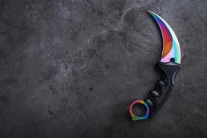 A dagger with a steel blade with a gradient color on a black background. photo