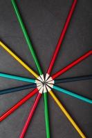 Multicolored pencils in the shape of a star on a black background. photo