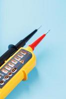 Yellow tester for step-by-step indication of voltage in an electrical circuit on a blue background photo