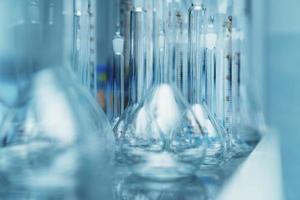 Laboratory flasks in a row on a shelf in the laboratory. photo