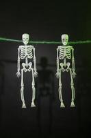 Decorative Skeletons hang on a rope on a gloomy background