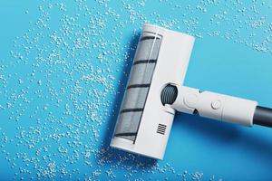 The nozzle of the turbo brush of a modern vacuum cleaner on a blue background cleans garbage. photo