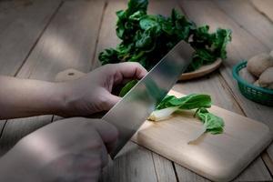 Pak choi cutting on a wooden cutting board. photo
