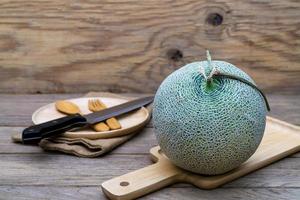 melon and knife on cutting board photo