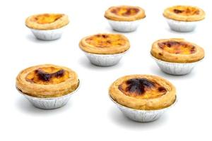 egg tart in aluminum foil cup isolated on white background photo