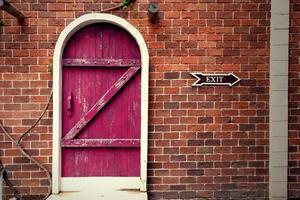 red vintage wooden door on brown brick wall photo