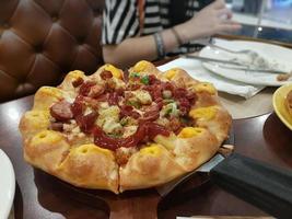 pizza en mesa de madera en restaurante foto