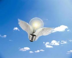 flying light bulb on sun and sky background. technology Concept photo