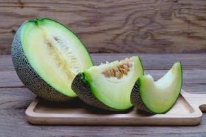 green sliced melon on wooden tray photo