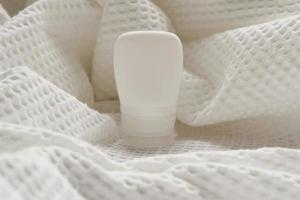 lotion tube mockup isolated on white fabric background. photo