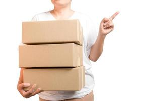 A parcel cardboard parcel box in a delivery woman person hands isolated on white background. Delivery service concept. Asian Young girl holding a package is a delivery business entrepreneur. photo