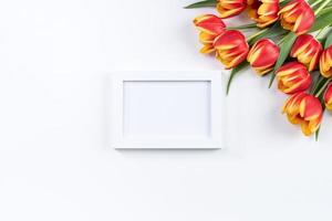 Mother's Day background, tulip flower bunch - Beautiful Red, yellow bouquet isolated on white table, top view, flat lay, mock up design concept. photo