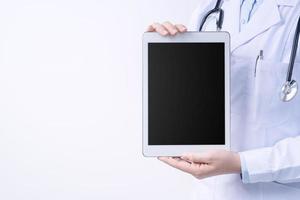 Doctor with stethoscope in white coat holding tablet, showing medical information, diagnosis, isolated on white background, close up, cropped view. photo