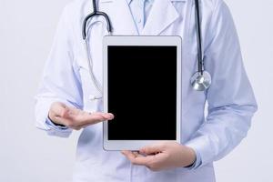 Doctor with stethoscope in white coat holding tablet, showing medical information, diagnosis, isolated on white background, close up, cropped view. photo