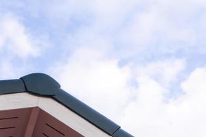 Gabled roof under a clouds and blue sky photo