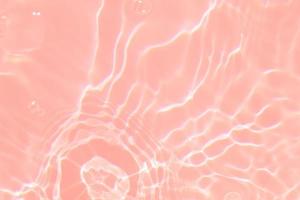 Defocus blurred transparent pink colored clear calm water surface texture with splash, bubble. Shining pink water ripple background. Surface of water in swimming pool. Tropical pink water textures. photo