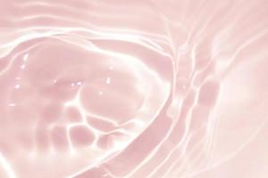 Defocus blurred transparent pink colored clear calm water surface texture with splash, bubble. Shining pink water ripple background. Surface of water in swimming pool. Tropical pink water textures. photo