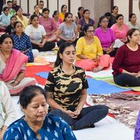 New Delhi, India, June 19 2022 -Group Yoga exercise session for people of different age groups in Balaji Temple, Vivek Vihar, International Yoga Day, Big group of adults attending yoga class in temple photo