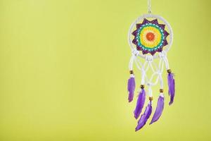 Handmade amulet dream catcher on a yellow background, protecting the sleeper photo