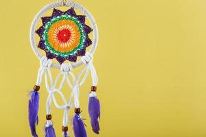 Amulet Dreamcatcher on a yellow background with free space protecting the sleeper photo