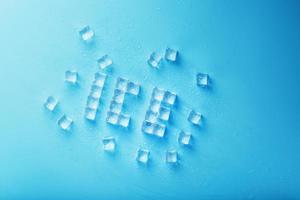 la palabra hielo es un patrón de cubitos de hielo sobre un fondo azul. foto