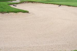 El fondo de la belleza del búnker del arenero se usa como un obstáculo para los torneos de golf por dificultad. y decora el campo para la belleza. hierba verde con textura de arena. foto