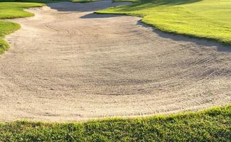 El fondo de la belleza del búnker del arenero se usa como un obstáculo para los torneos de golf por dificultad. y decora el campo para la belleza. hierba verde con textura de arena. foto