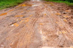 camino de tierra, el suelo rojo y los caminos rurales estaban empapados de agua por la fuerte lluvia. caminos difíciles, tráfico inconveniente foto