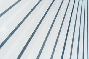 Metal siding with a corrugated pattern of white color diagonally. photo