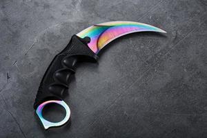 A dagger with a steel blade with a gradient color on a black background. photo