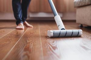 Turbo brush cordless vacuum cleaner close-up cleans the parquet in the house. photo