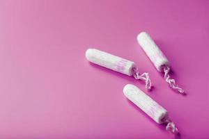 Cotton tampons on a pink background with a free space photo