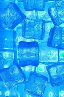 Ice cubes with blue backlight in the freezer close-up in full screen photo