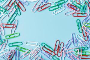 Multicolored paper clips on a blue background. photo