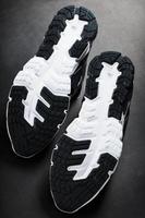 The black and white sole of trendy sports sneakers is a close-up in full screen. photo